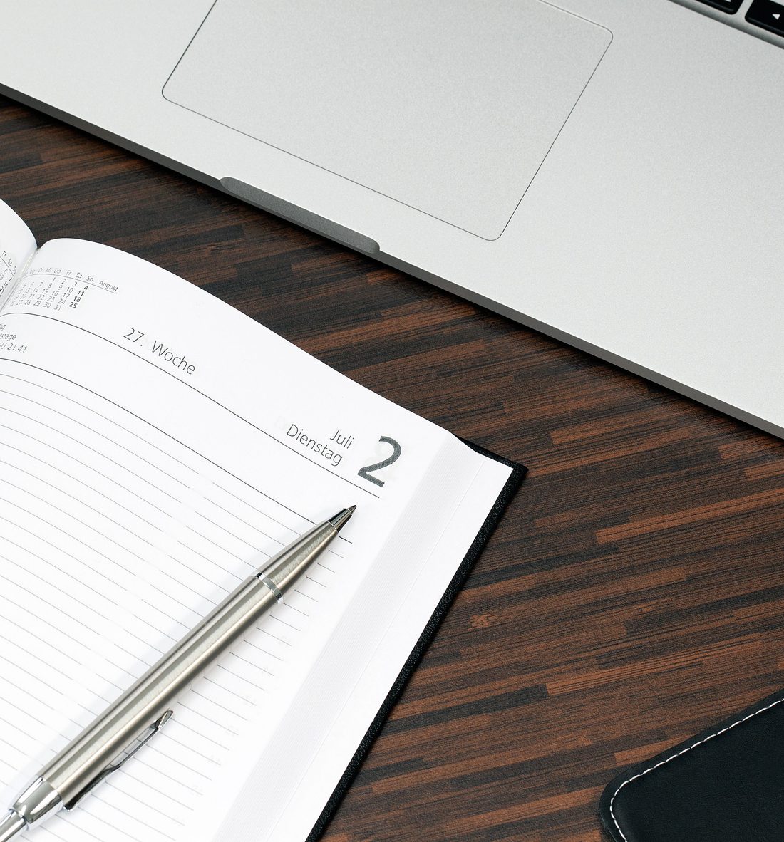 An open planner and pen on a desk